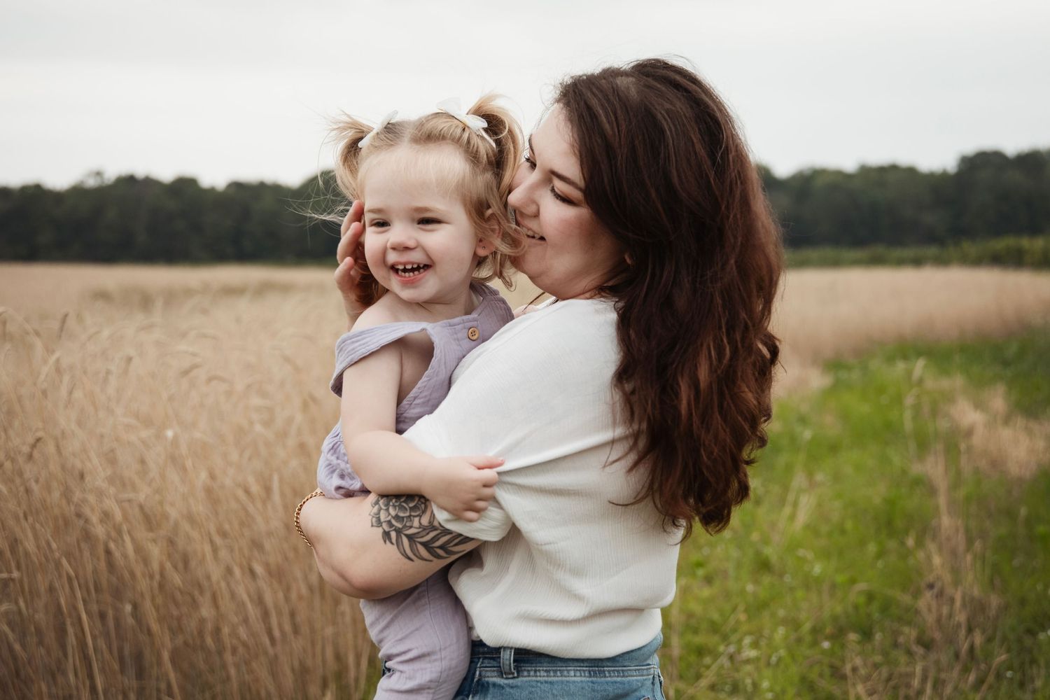Family outdoor photo session in a golden wheat field at sunset.