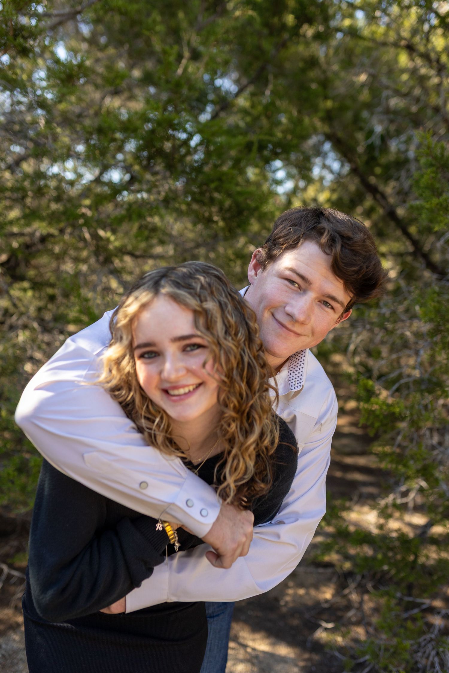 Candid outdoor portrait sequence showing joyful piggyback moment among trees.