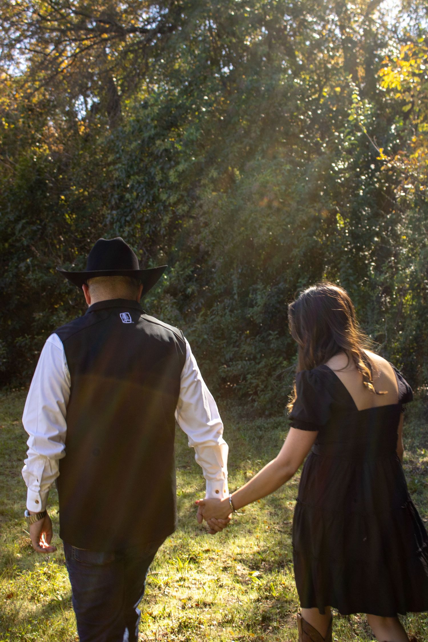 A series of silhouetted figures walking through a sunlit forest path with golden autumn light filtering through trees.