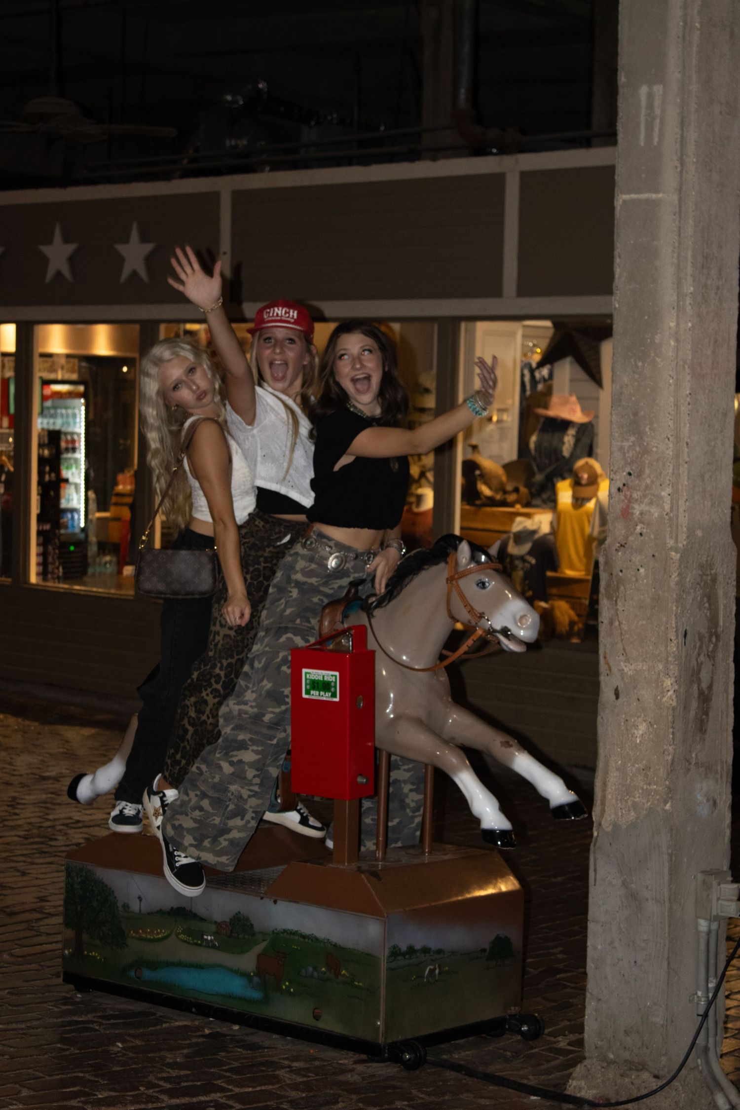 Group riding mechanical bull at night venue.
