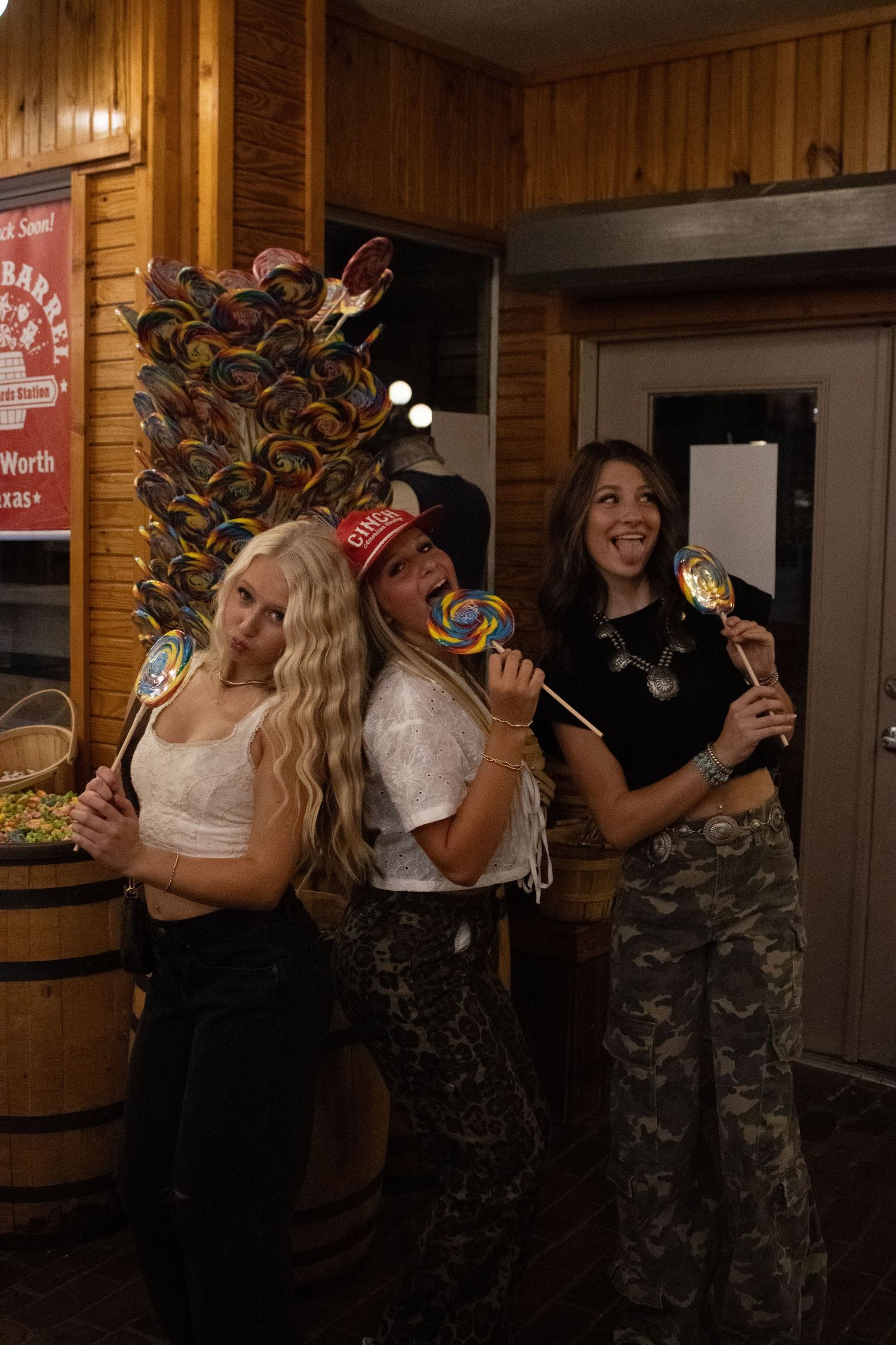 Group enjoying drinks and laughter in wood-paneled bar interior.