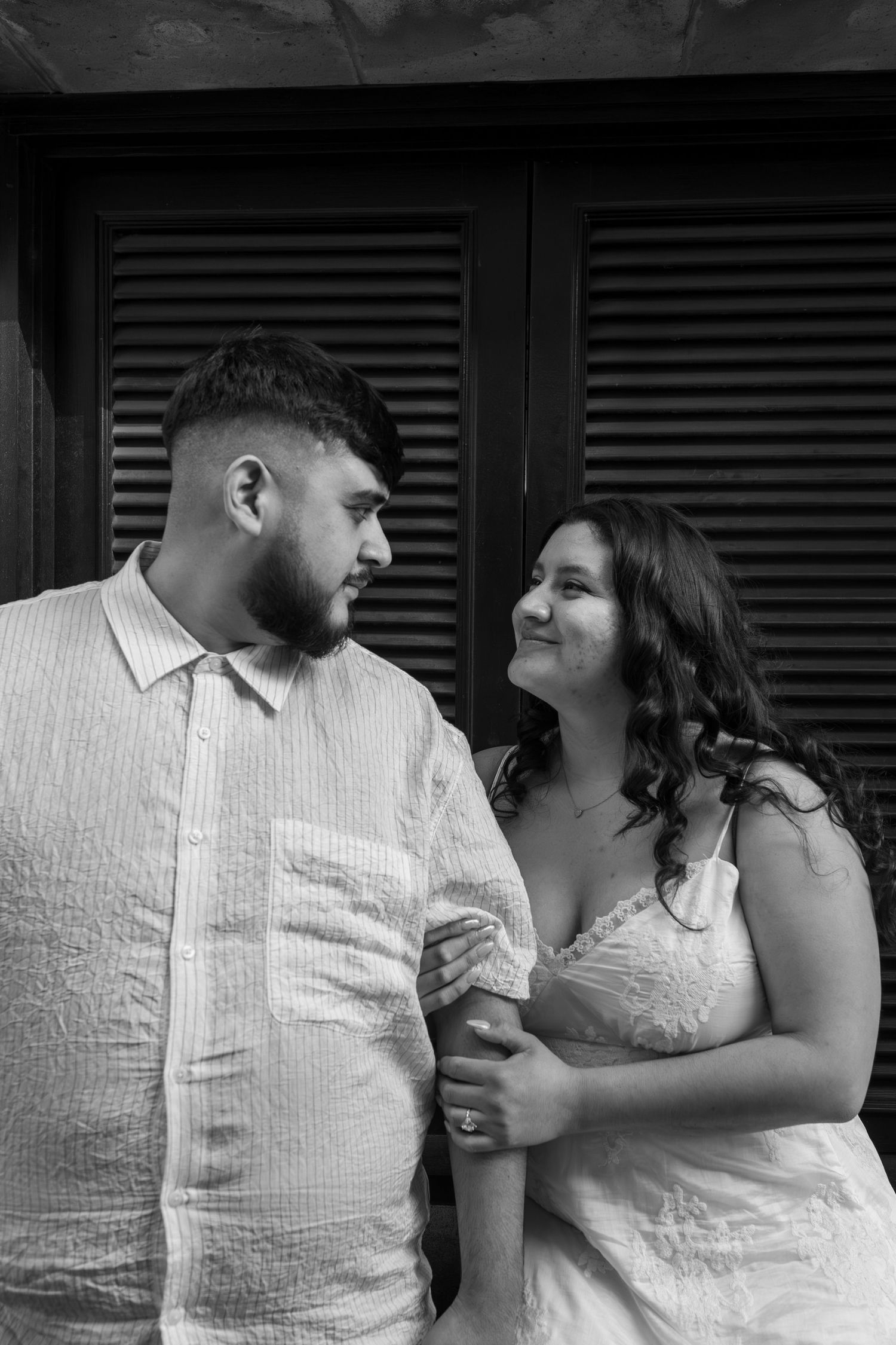 A romantic black and white photo sequence shows a couple in white clothing sharing tender moments together.