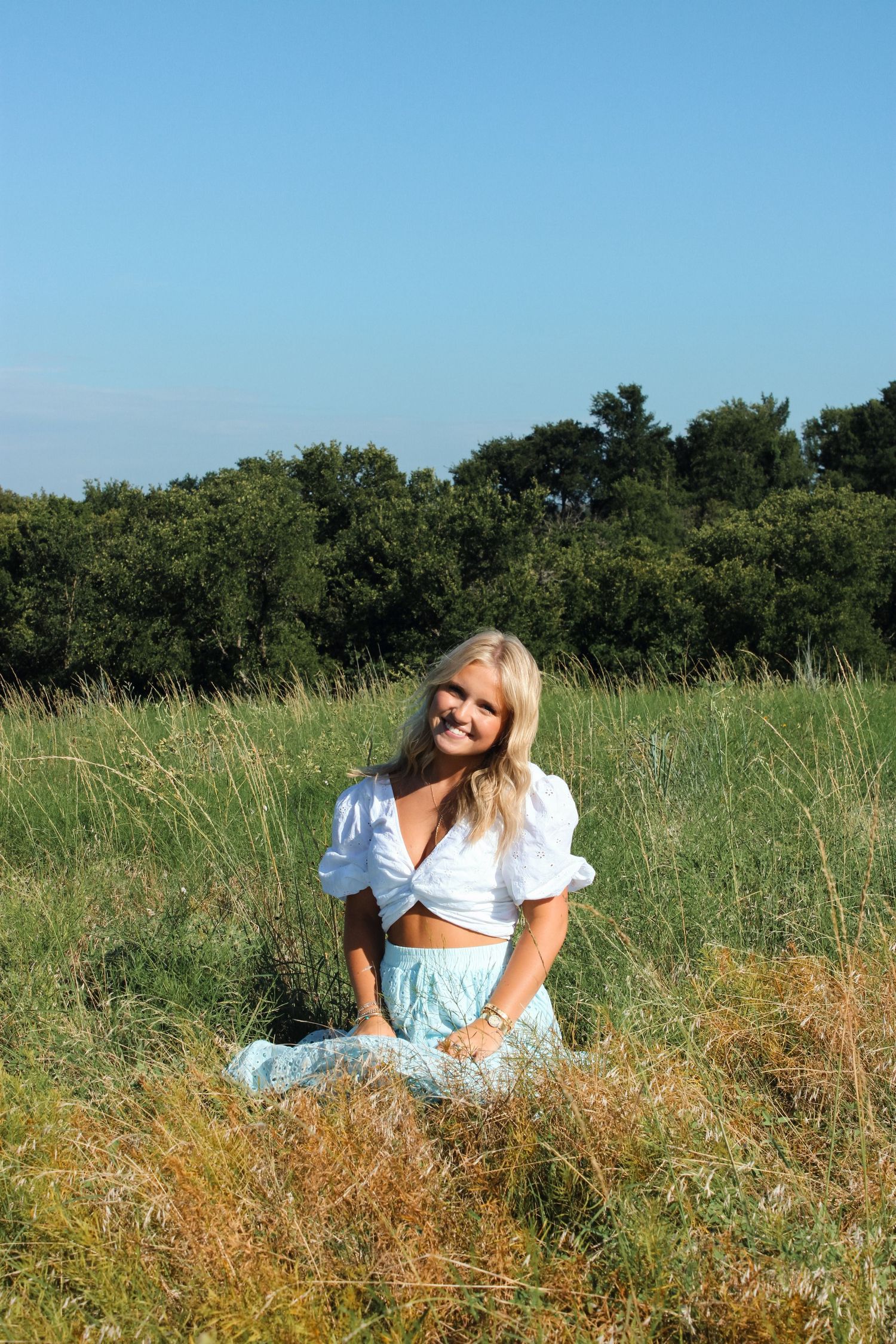 Person in light clothing relaxing in sunny meadow.
