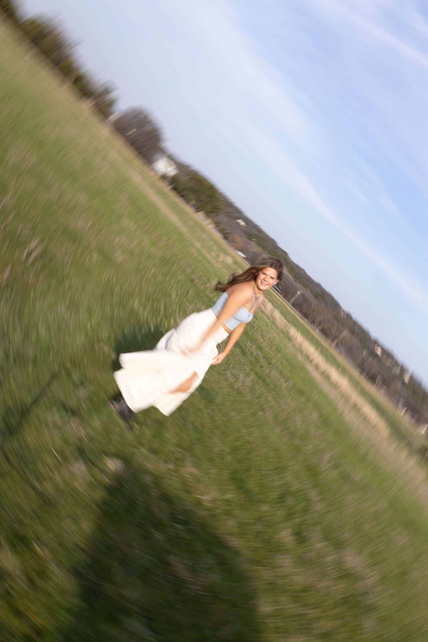 A series of four tilted landscape photos showing a blurred figure in white moving across a green grassy field.