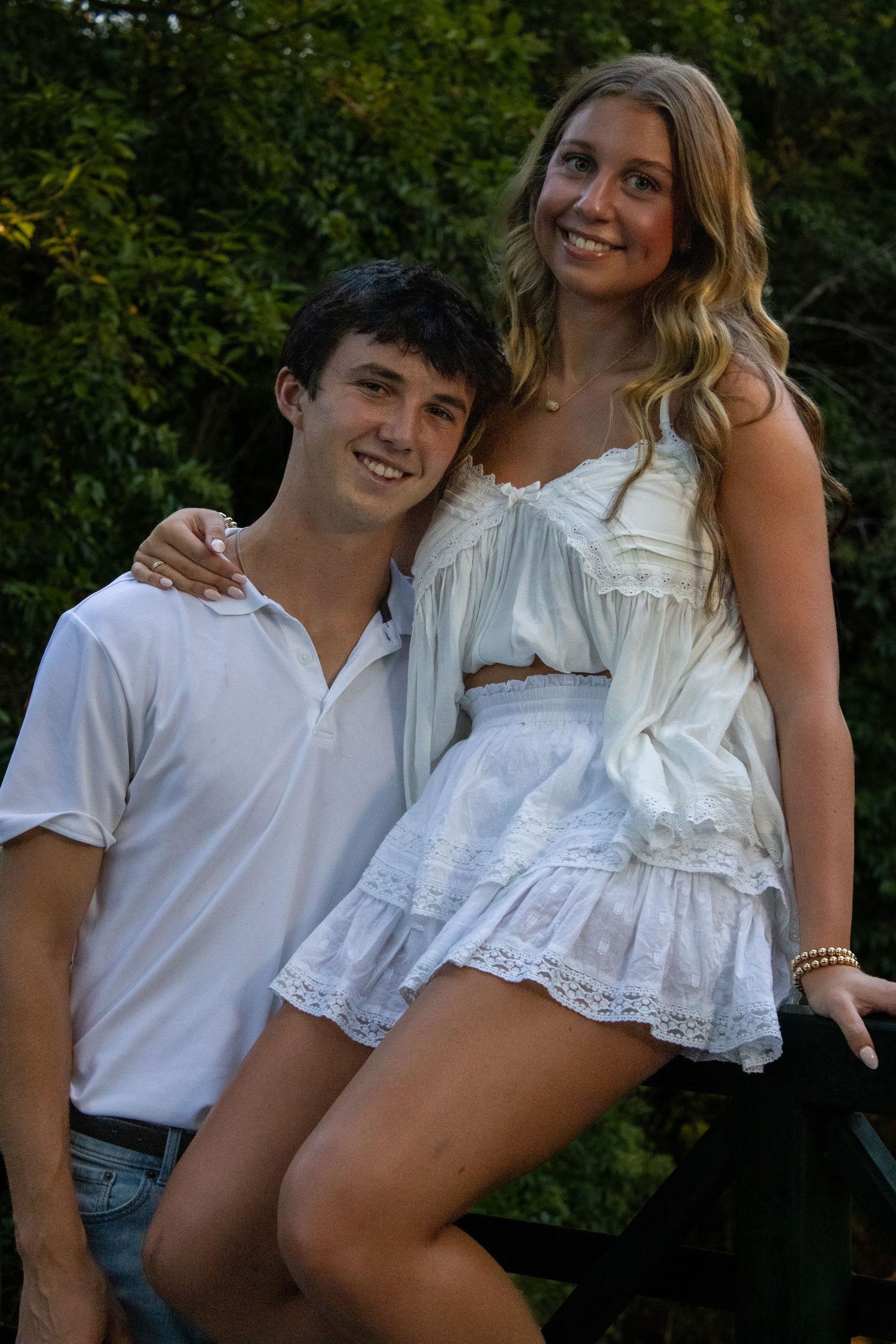 Couple in casual summer outfits posing together outdoors.