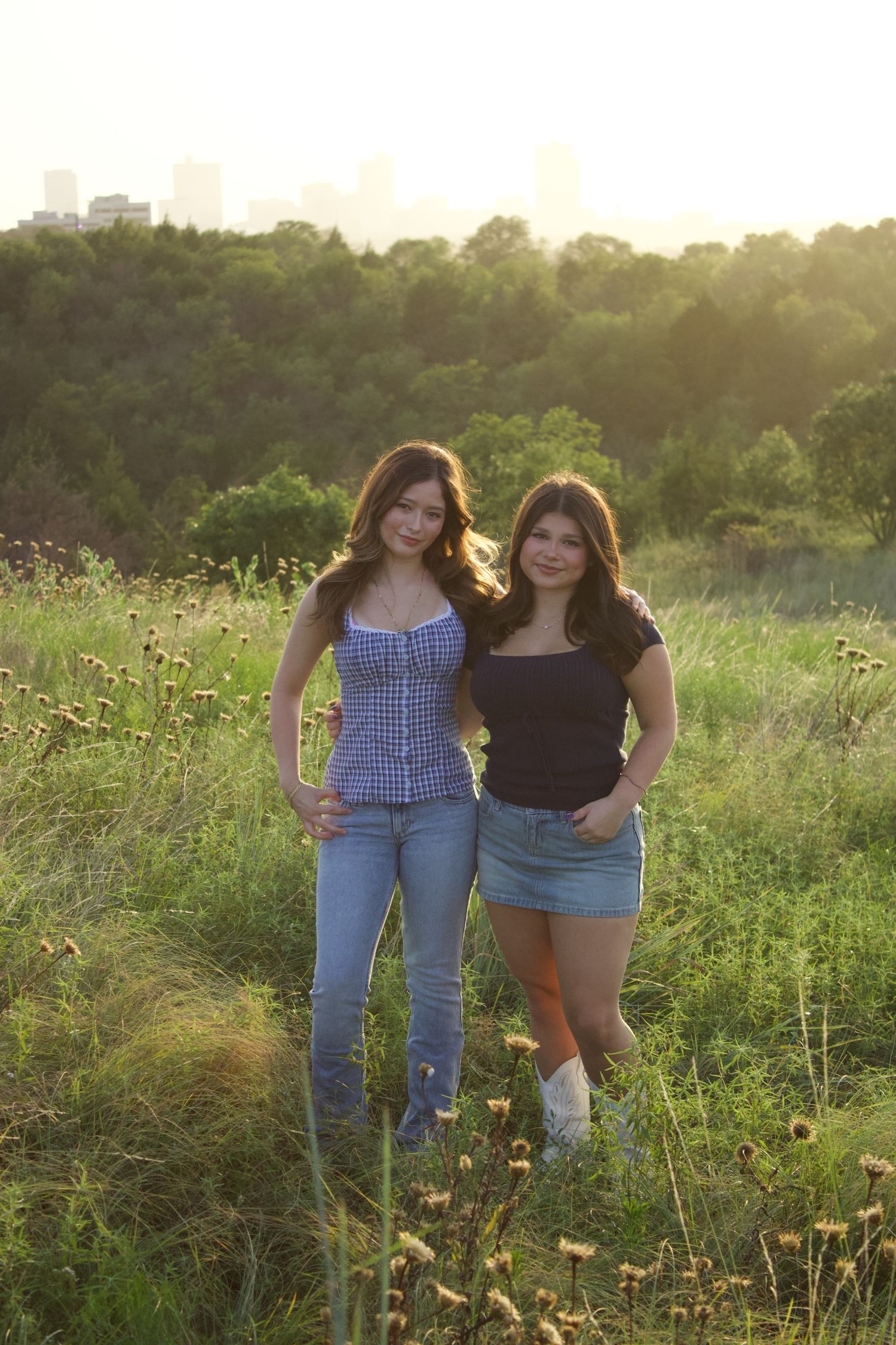 Friends enjoying a sunny day together in a wildflower meadow at sunset.