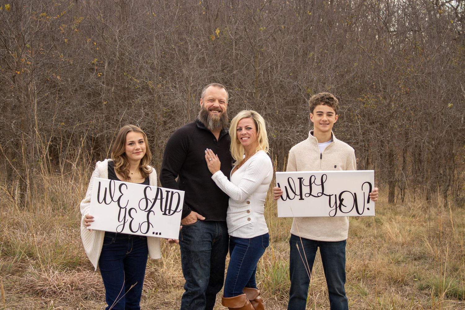 Family holds up white signs in a fall field setting creating a heartwarming message reveal sequence.