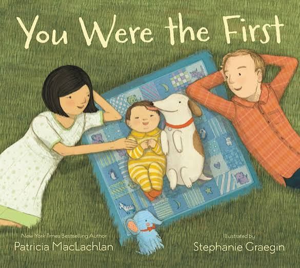 Children's book cover showing parents and dog lying on grass with baby, titled You Were the First by Patricia MacLachlan.