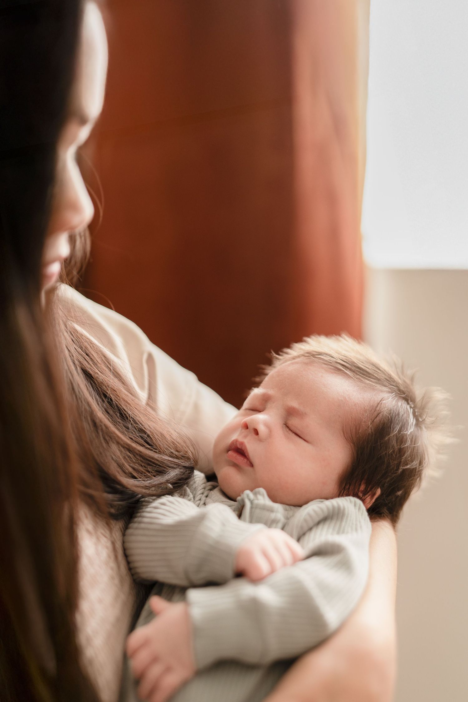 Mother holding newborn baby during an in-home newborn session