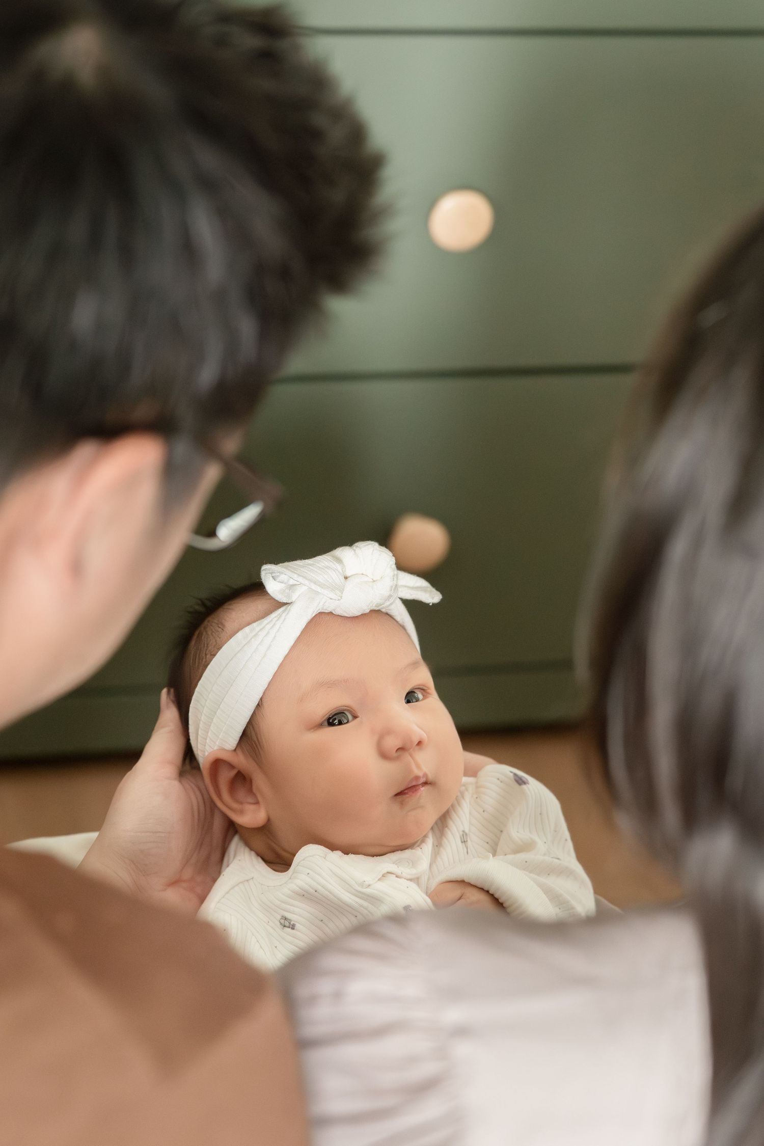 family holding newborn baby during an in-home newborn session