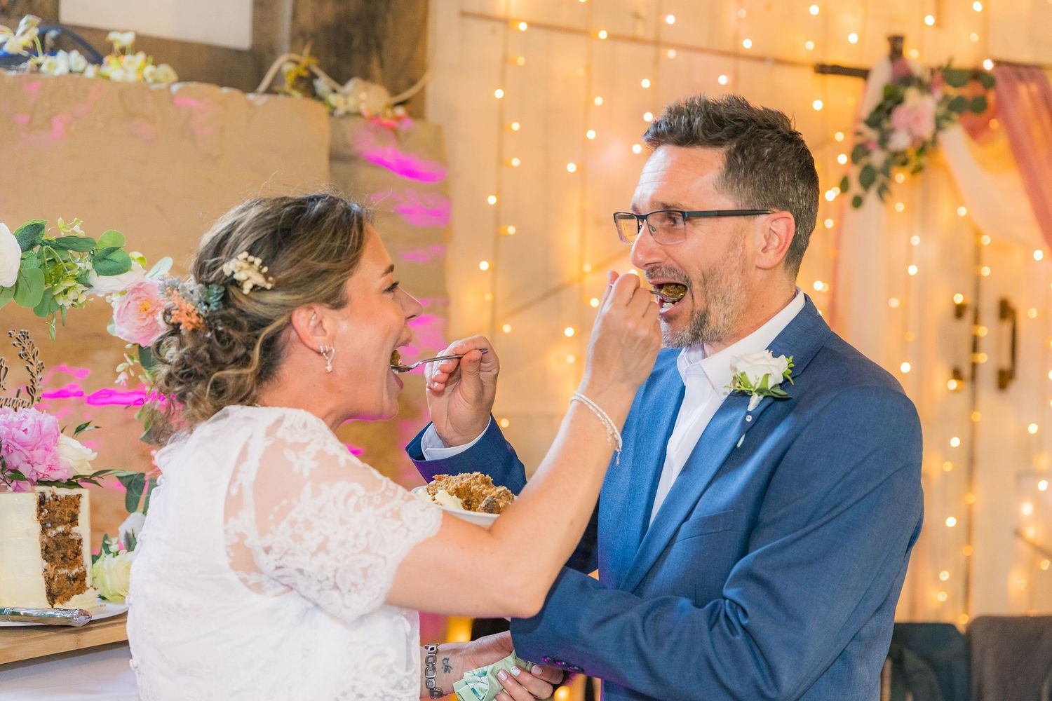 Wedding cake cutting ceremony captured by R&S Oxfordshire Photographers, full of joy and candid emotion.