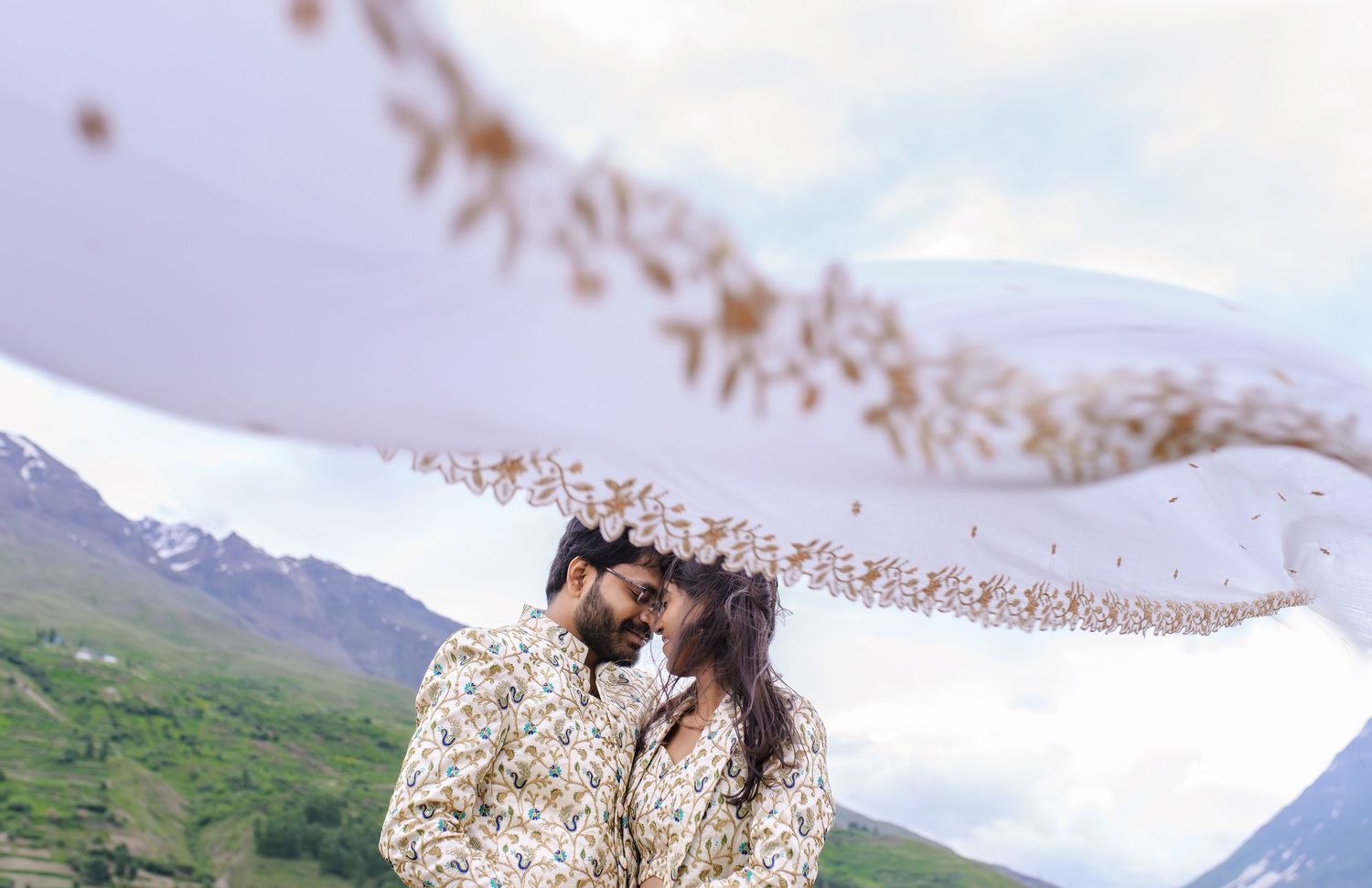 Scenic mountain views with wildflowers swaying in the foreground during golden hour.