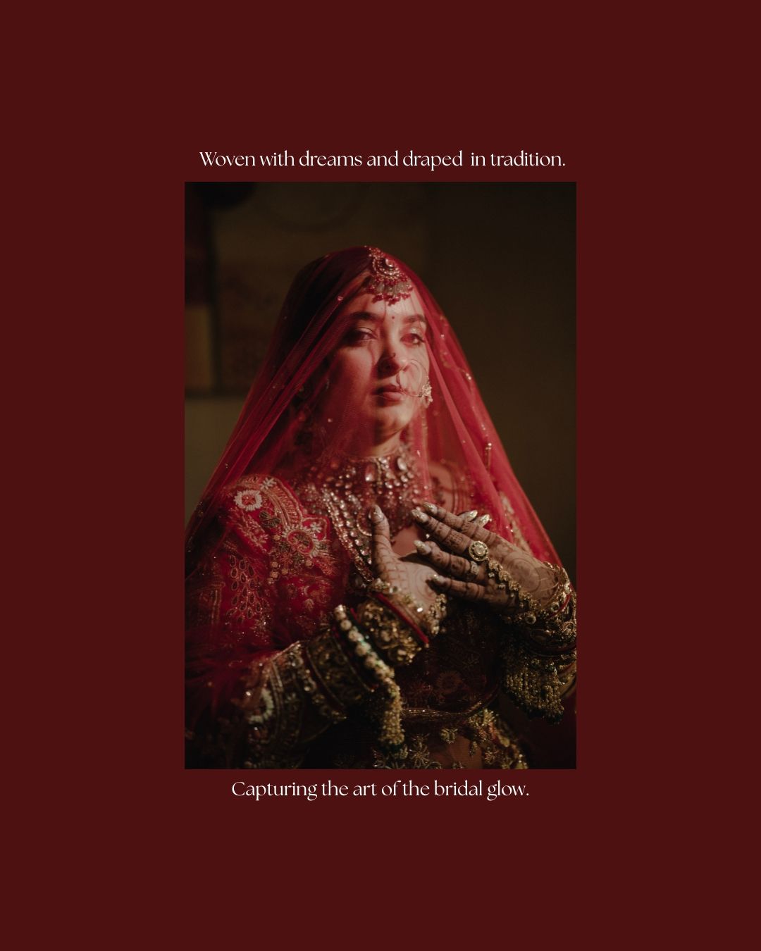 A bride in a red embroidered lehenga and dupatta adorned with gold jewelry, captured in a dramatic portrait.