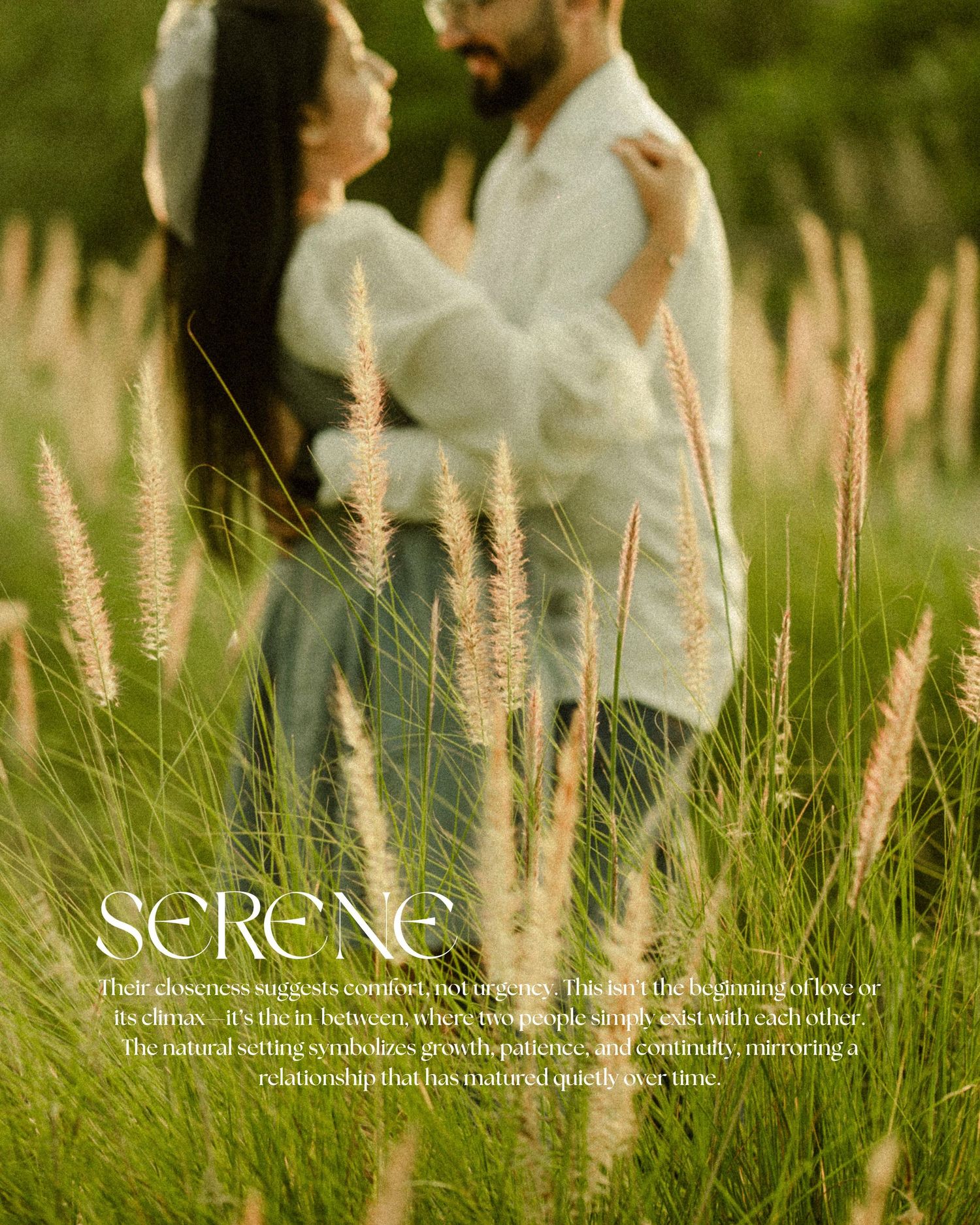 Couple embracing in a serene golden grass field, romantic outdoor engagement photo with soft natural lighting.