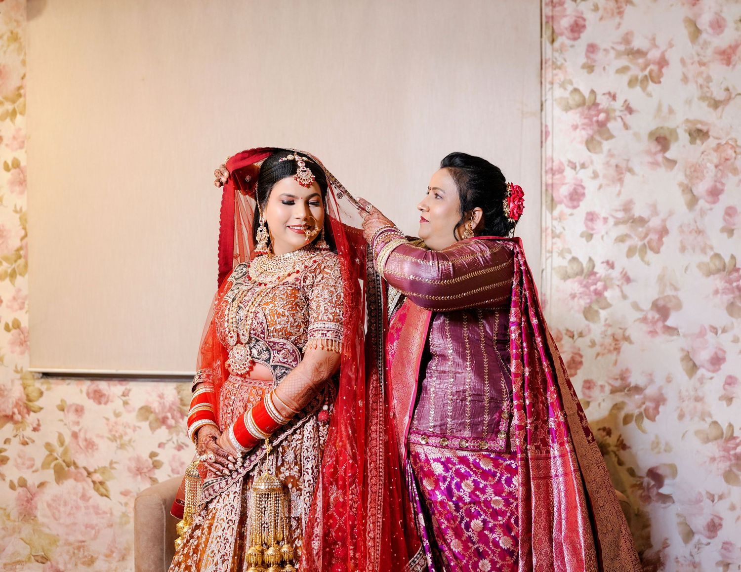 Traditional Indian wedding outfits in rich red and purple colors with intricate embroidery and embellishments.