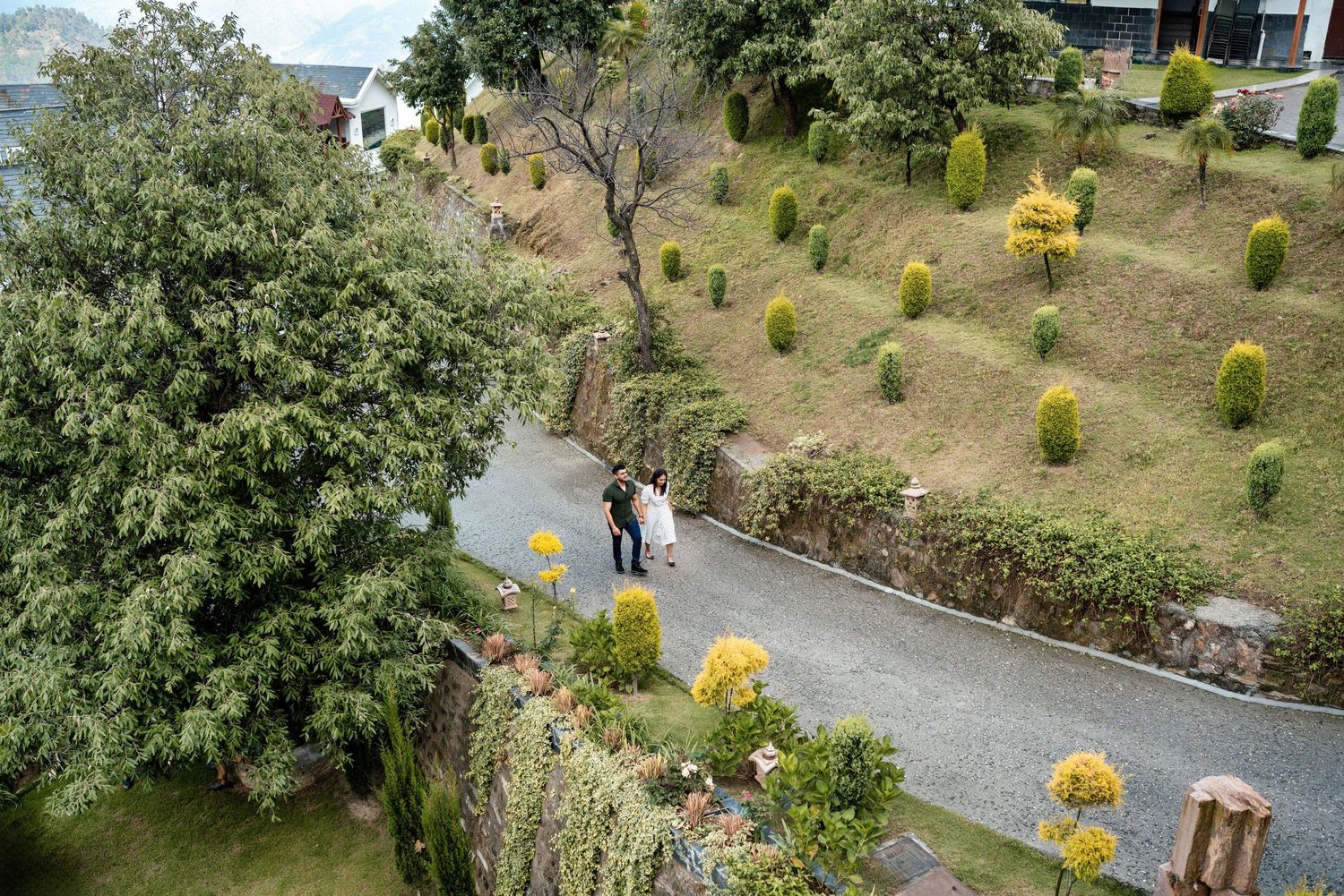 Aerial view of landscaped garden paths with trees and yellow decorative elements.