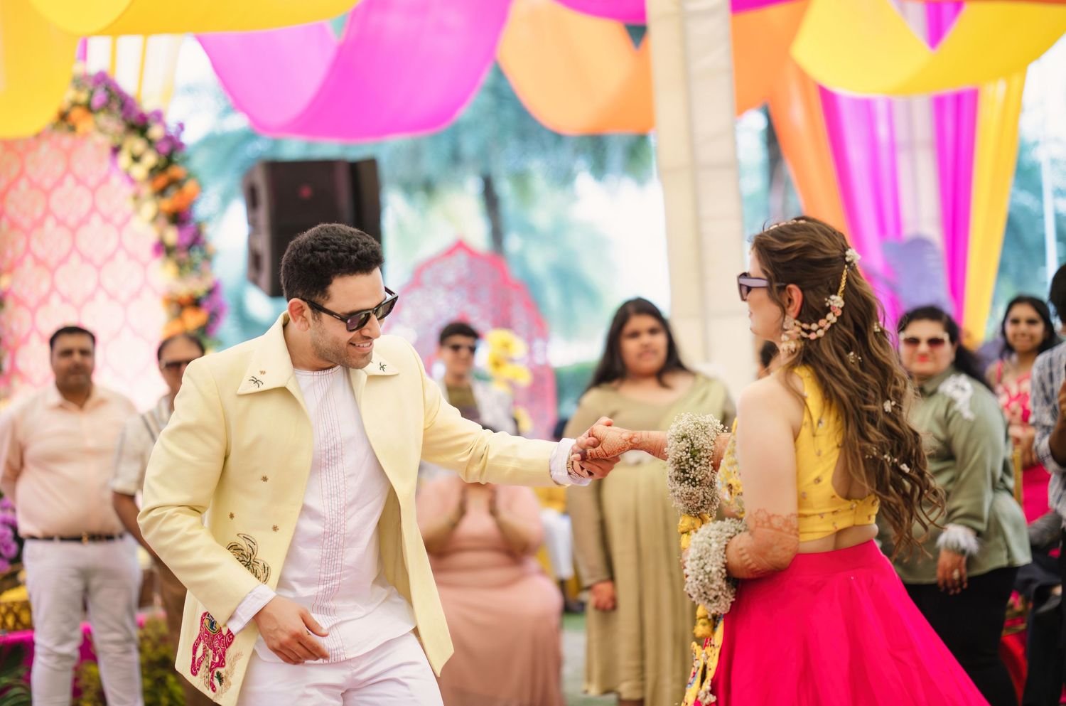 Vibrant outdoor celebration with colorful decorations and festive atmosphere at an Indian wedding ceremony.