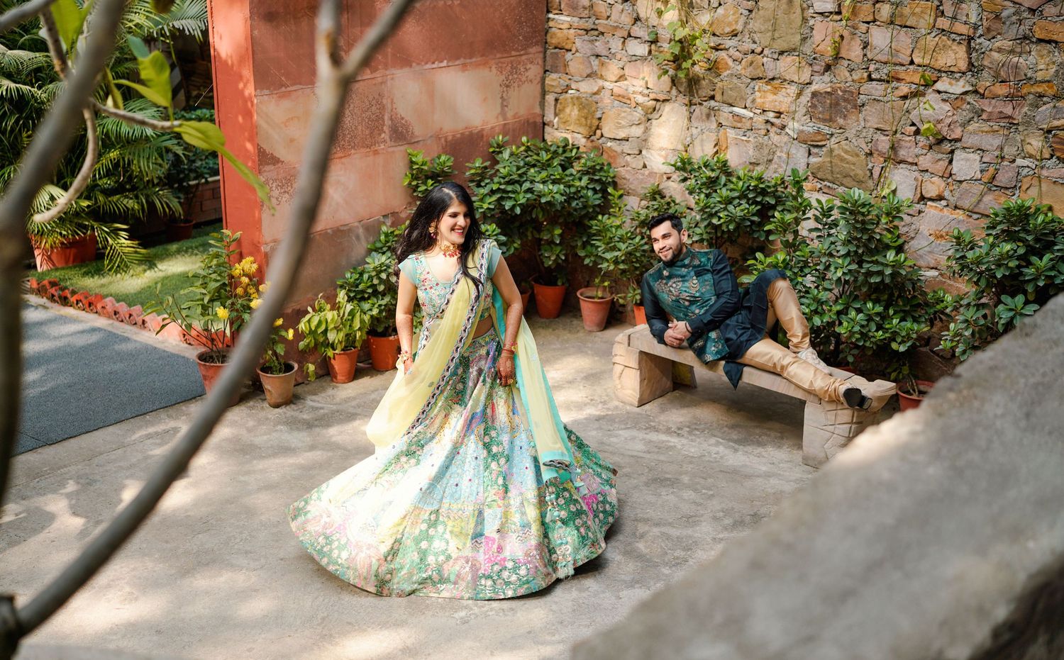 Wedding photography captured in a rustic setting with stone walls and outdoor pathways.