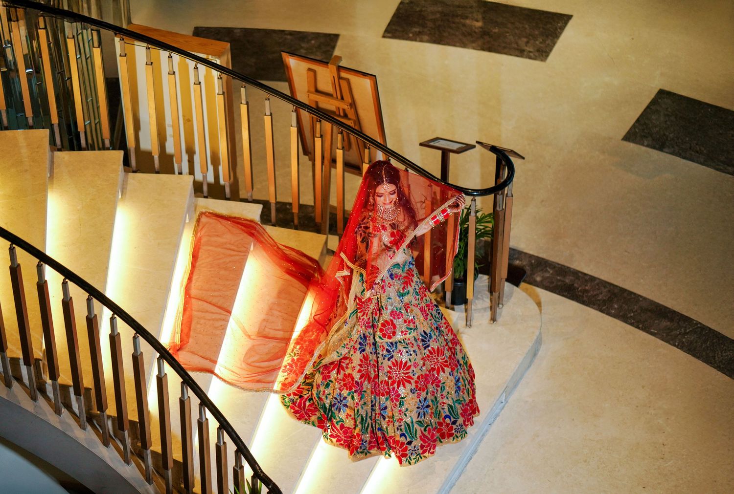 Wedding venue staircase with ornate railing and warm lighting creates elegant ambiance.