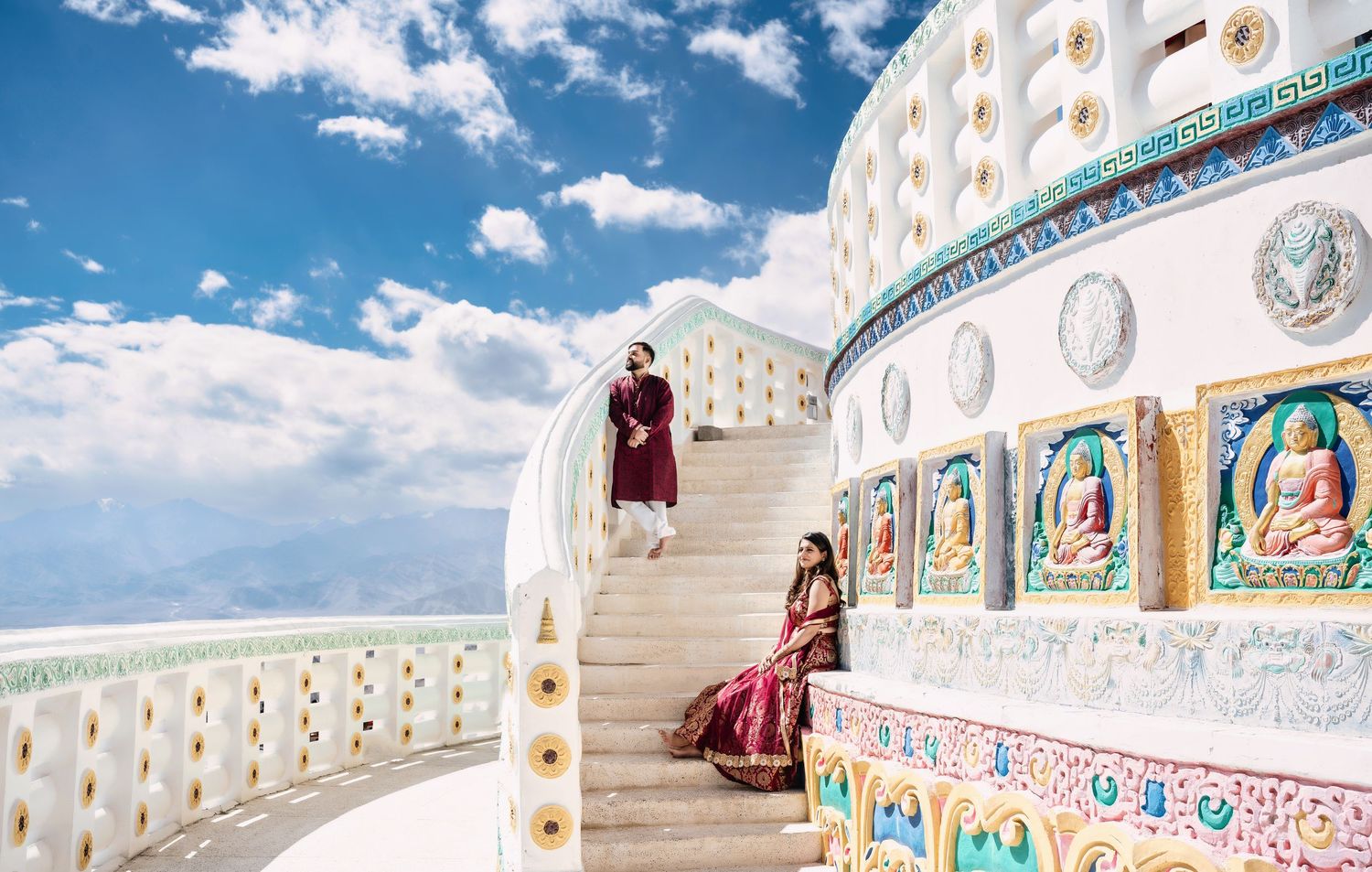 White temple architecture with colorful murals and ornate details under blue sky.