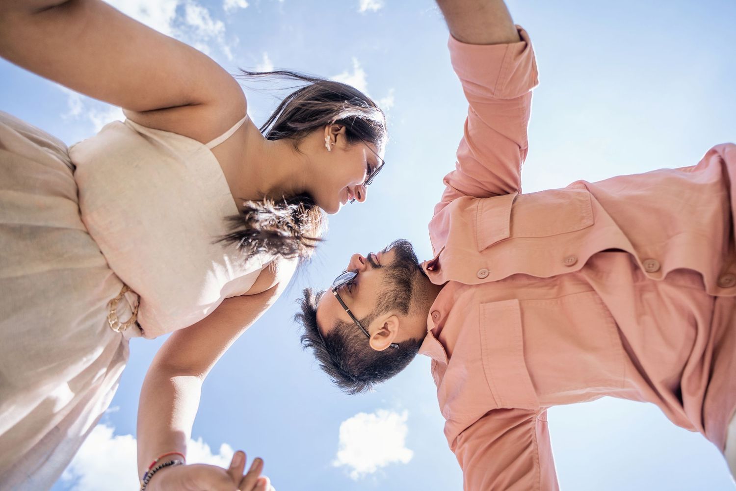 People enjoying a joyful moment against a bright blue sky with sunlight.