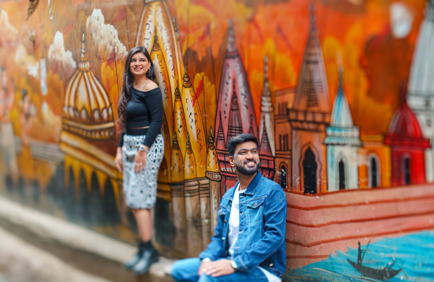 Vibrant orange and blue painted murals create colorful urban backdrop.