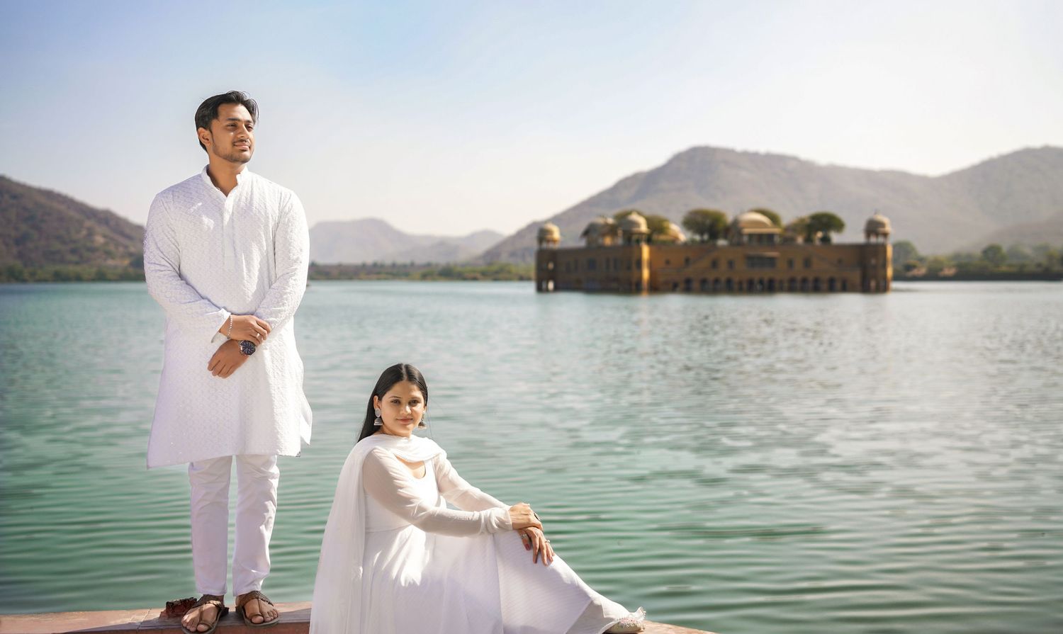 Peaceful lakeside scene with mountains and clear water reflecting the landscape.