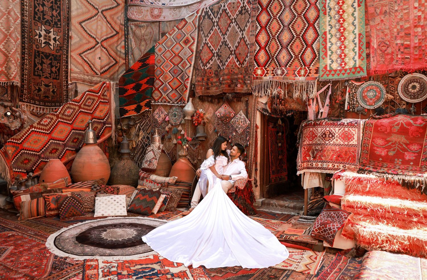 Traditional Middle Eastern carpets and textiles displayed in a colorful marketplace setting.