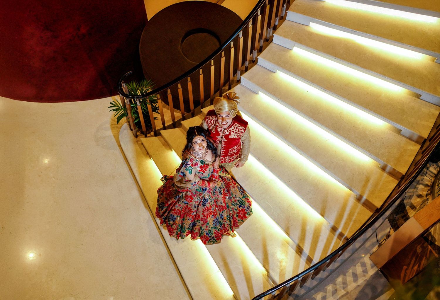 Elegant curved staircase with illuminated steps and wooden railings in a luxury venue.