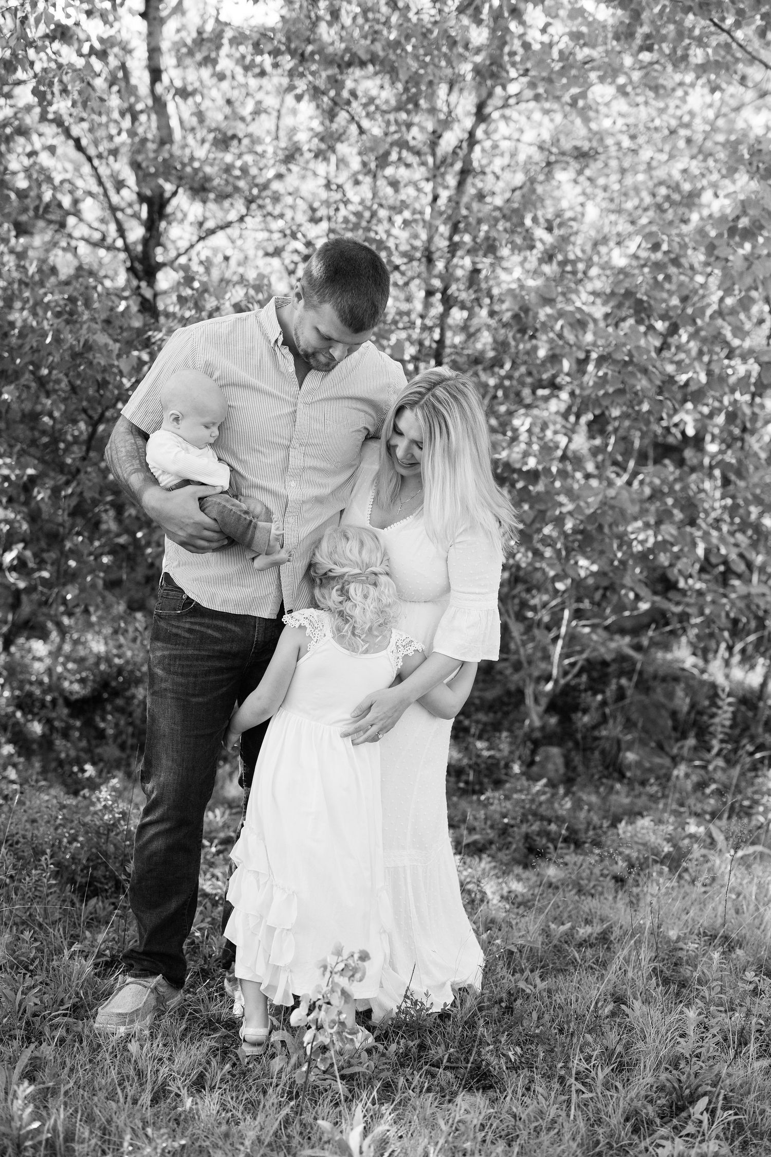 Series of intimate couple portraits in a sunlit field with white dress and casual attire.