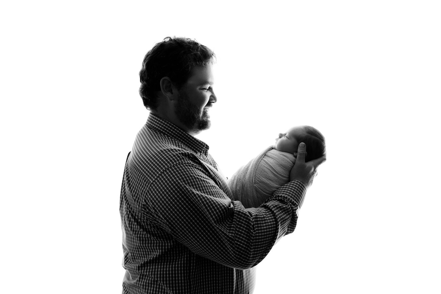 Black and white silhouette portrait showing intimate family moment.