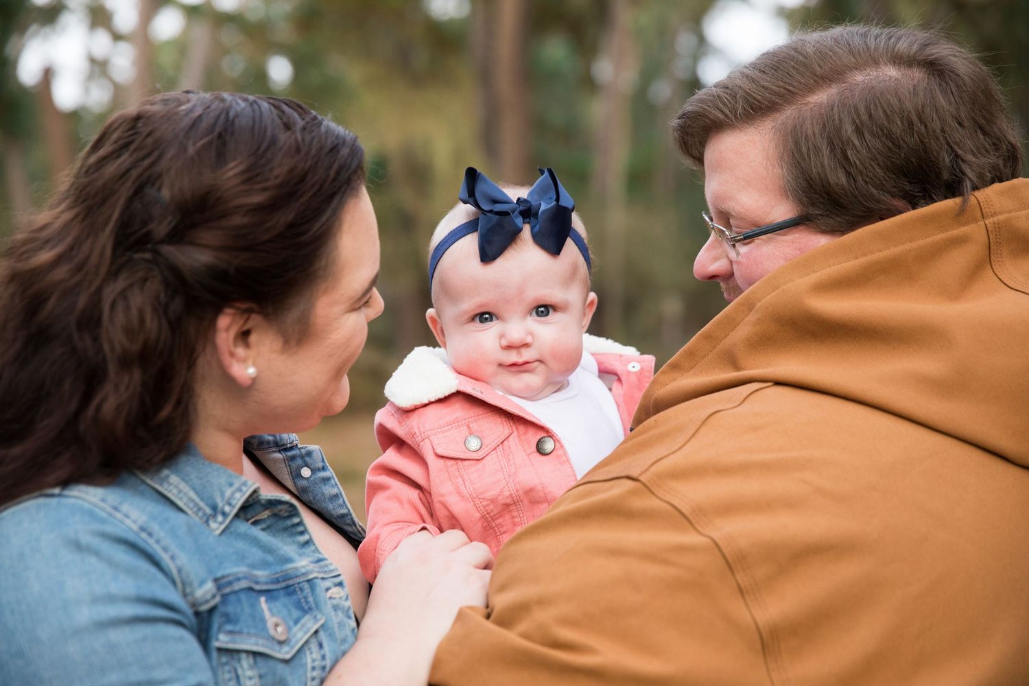 Outdoor family photography session featuring casual denim and earth tone clothing.