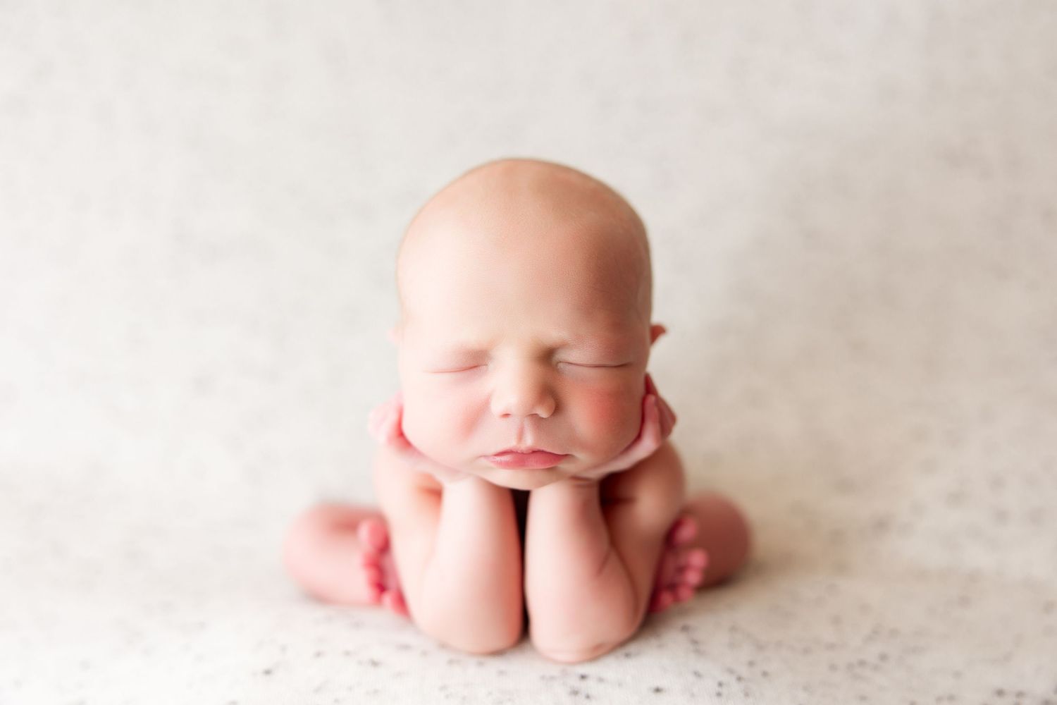 Close-up of newborn details against white textured backdrop.