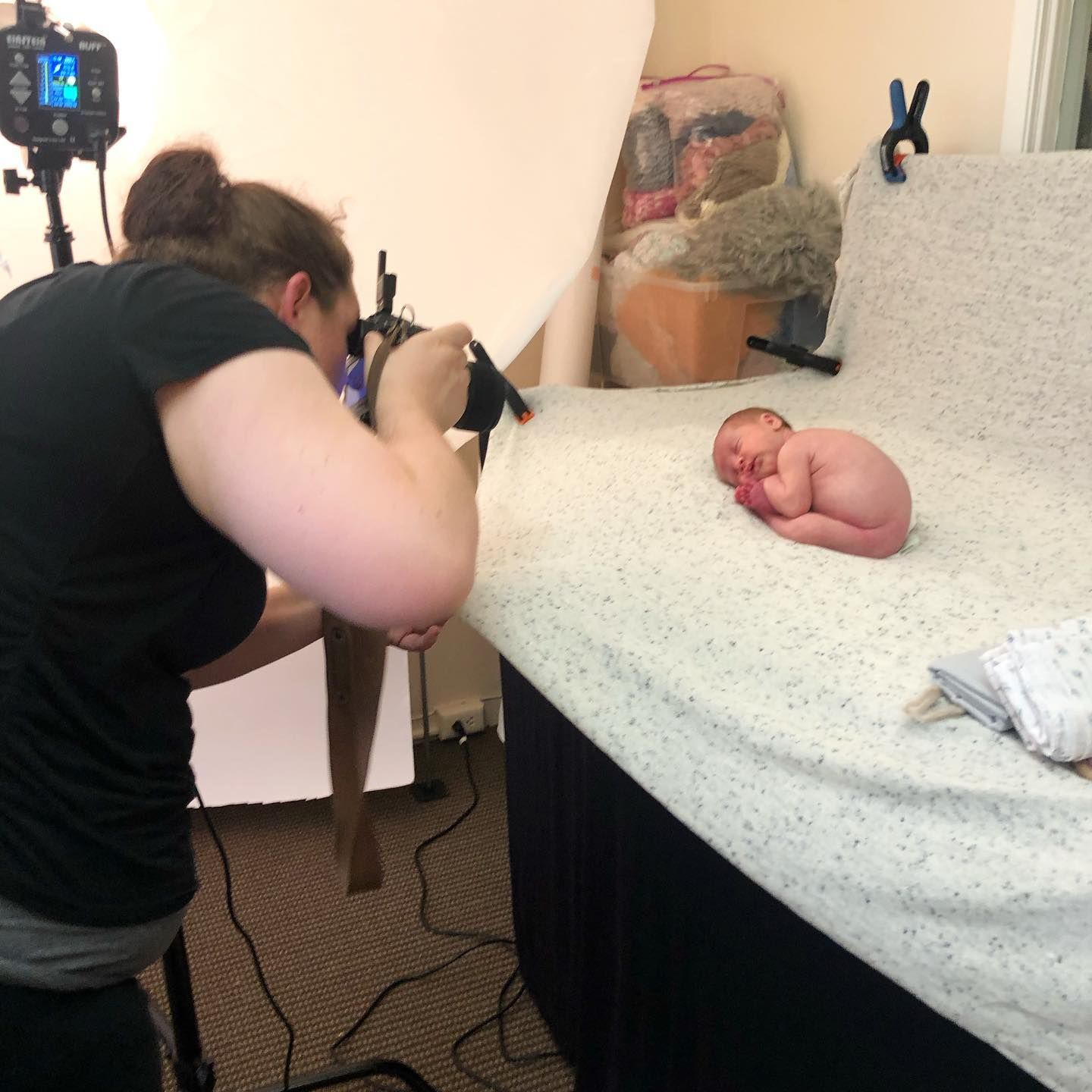 Behind-the-scenes view of a photography session setup with camera equipment and white backdrop.
