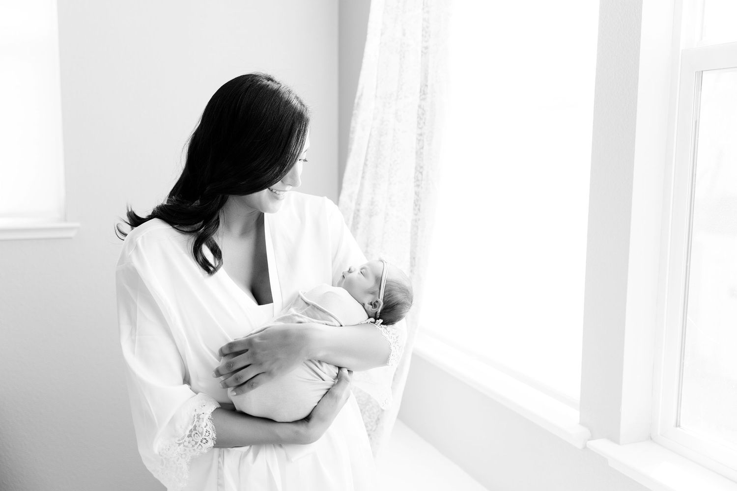 Black and White images of a new mom holding her newborn girl in their home