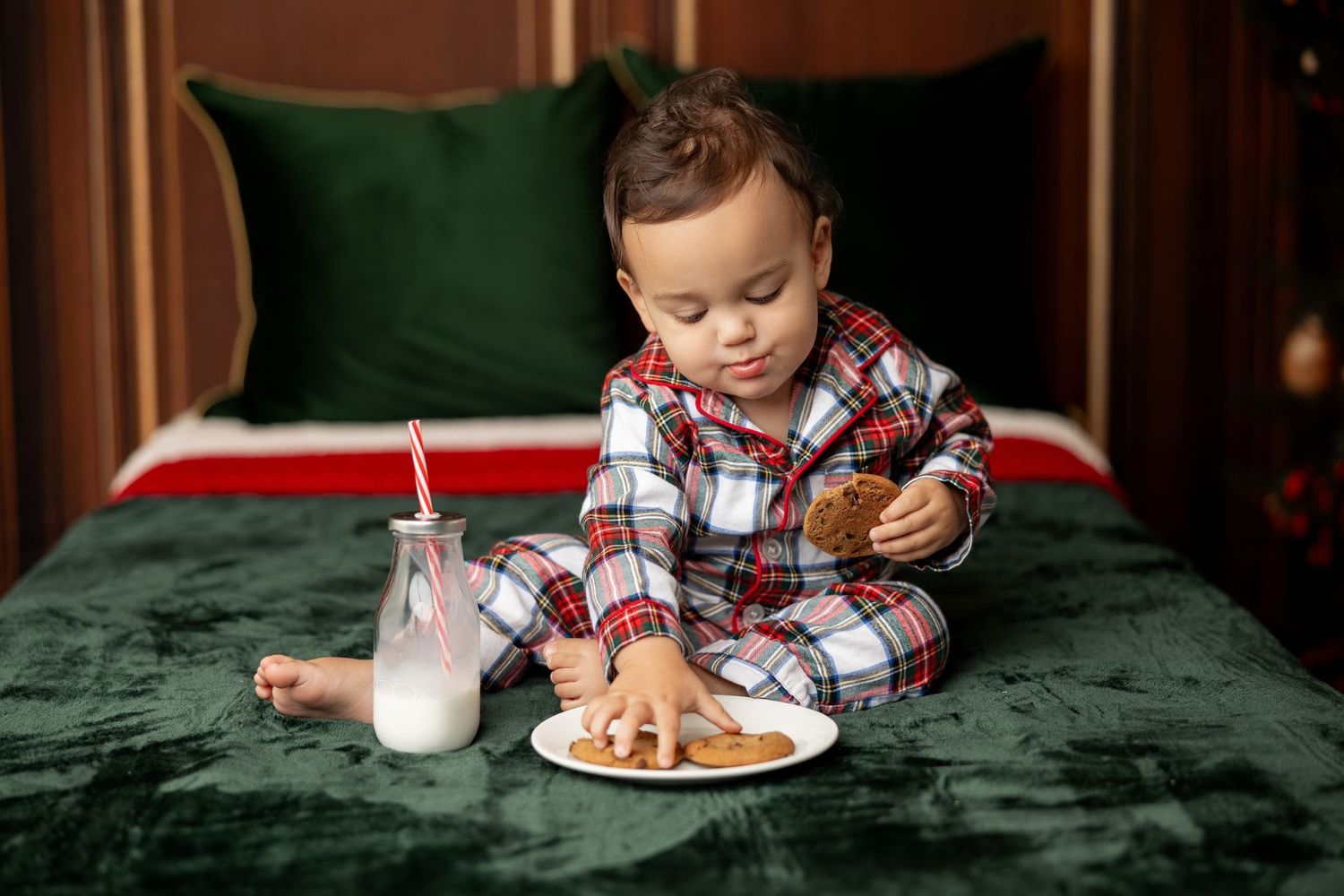 Toddler in plaid Christmas pajamas with milk and cookies at a Milk & Cookies holiday mini session in Pacific Grove
