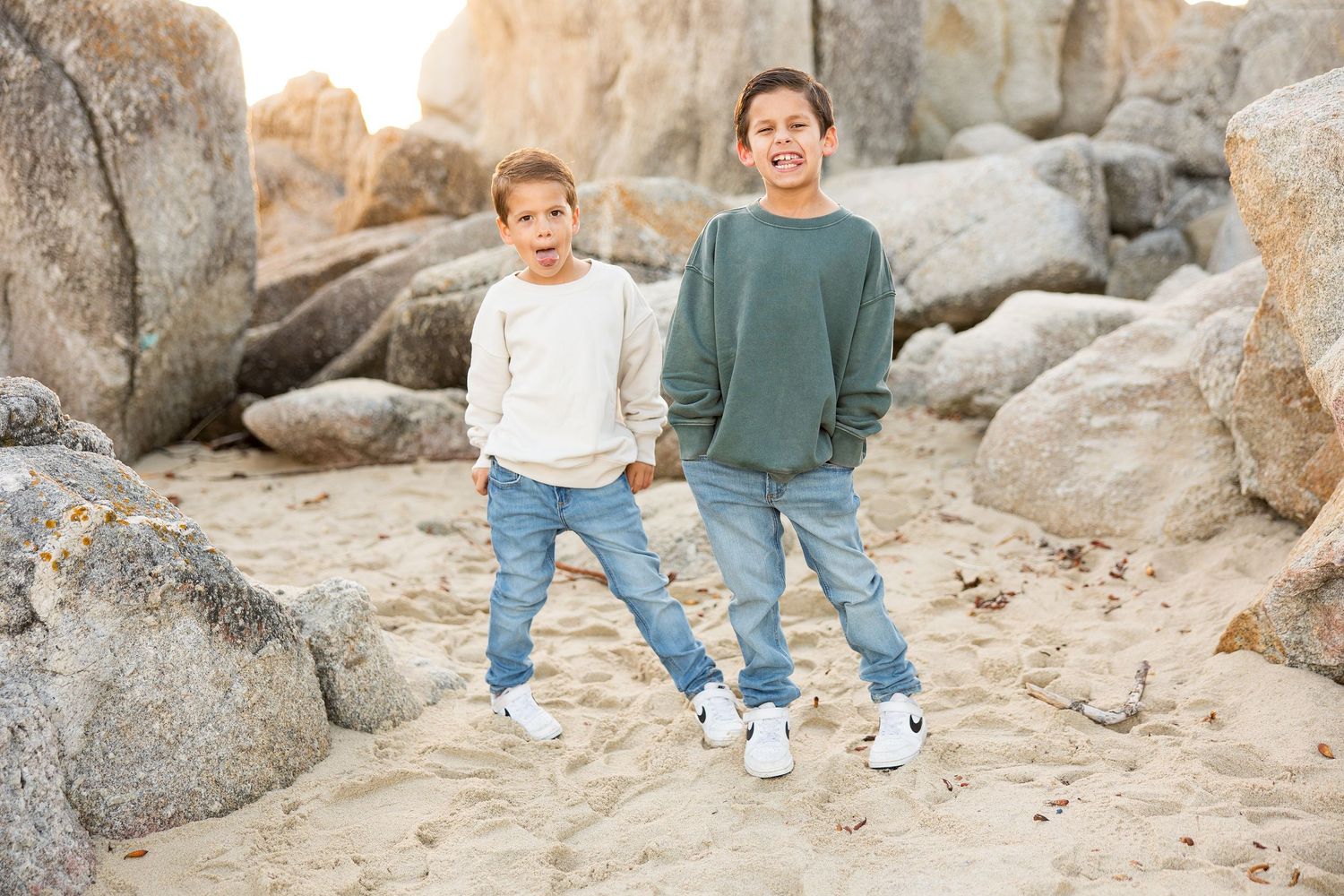 Two people posing together on rocky terrain wearing coordinated casual outfits.