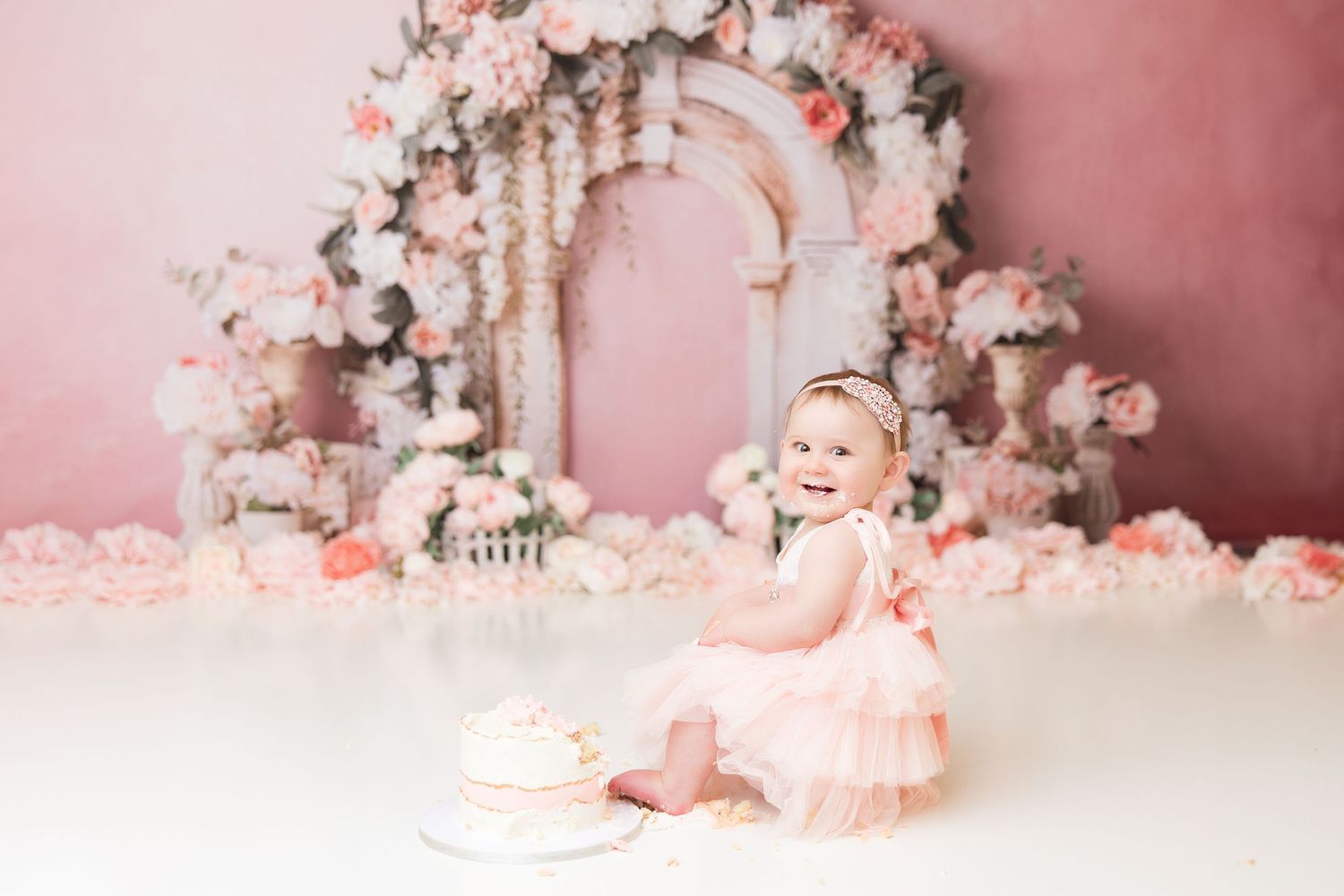 Elegant pink rose decorated photo setup with vintage architectural elements.