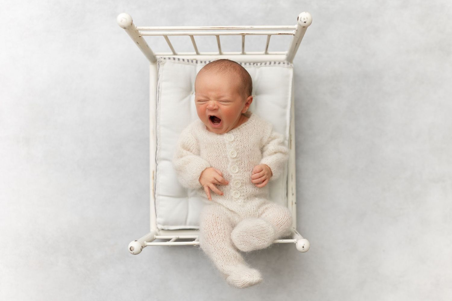Collection of five newborn baby photos showing sleeping poses on white backgrounds in soft lighting.