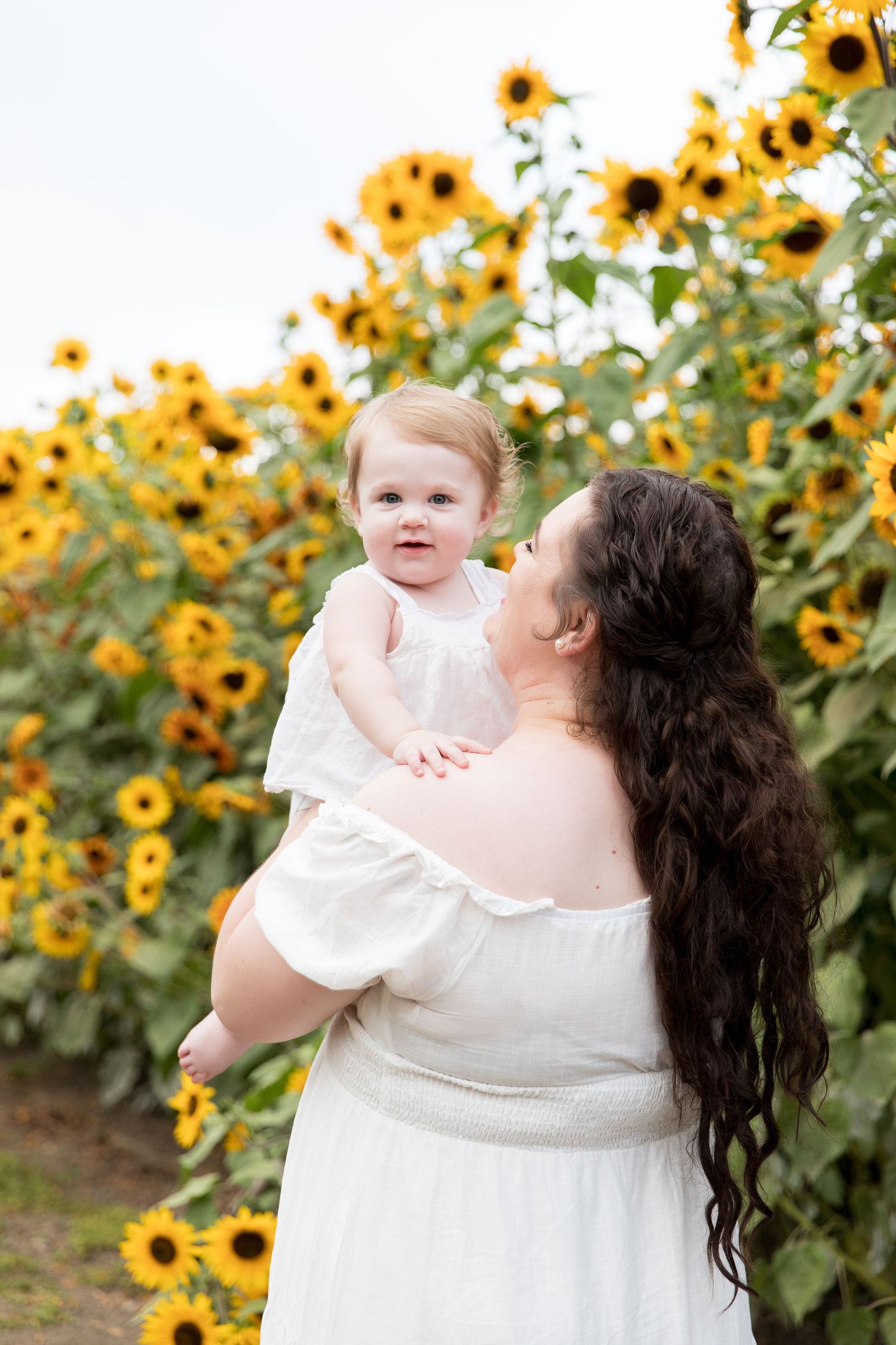 A tender moment captured against a backdrop of bright yellow sunflowers.