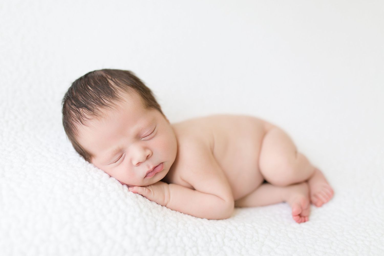 Sleeping newborn on clean white background in minimalist style.