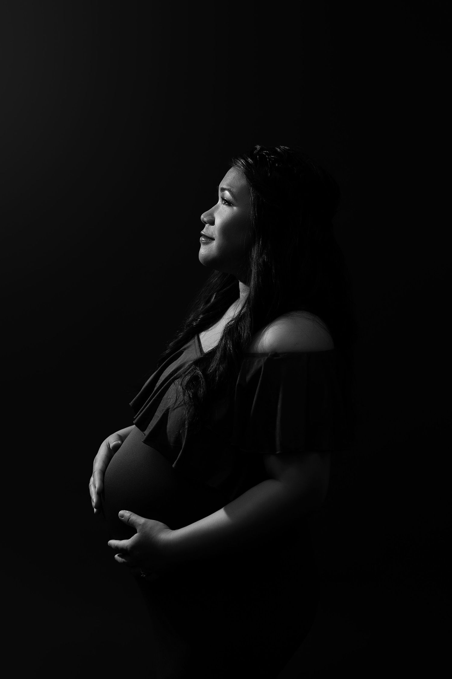 Dramatic black and white maternity portraits with artistic lighting.