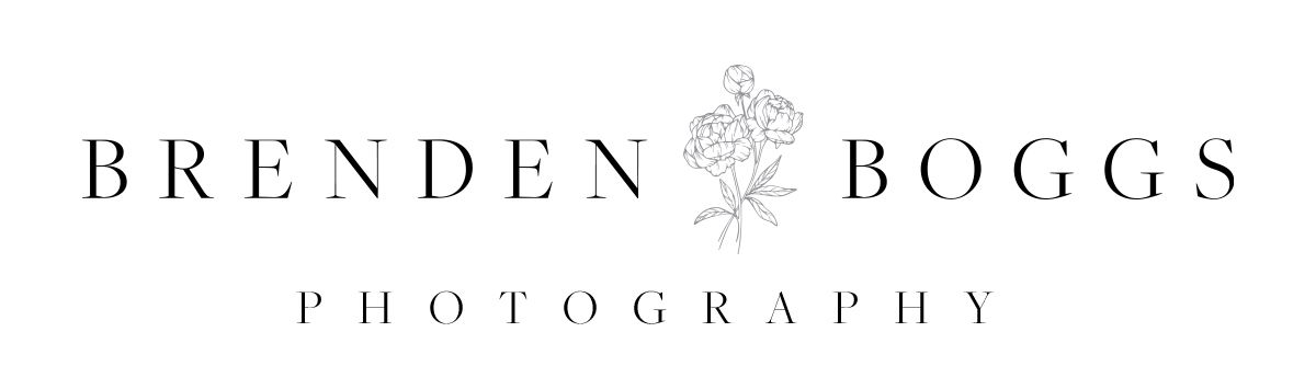 Elegant photography logo design with decorative floral emblem between text in sophisticated serif typography.