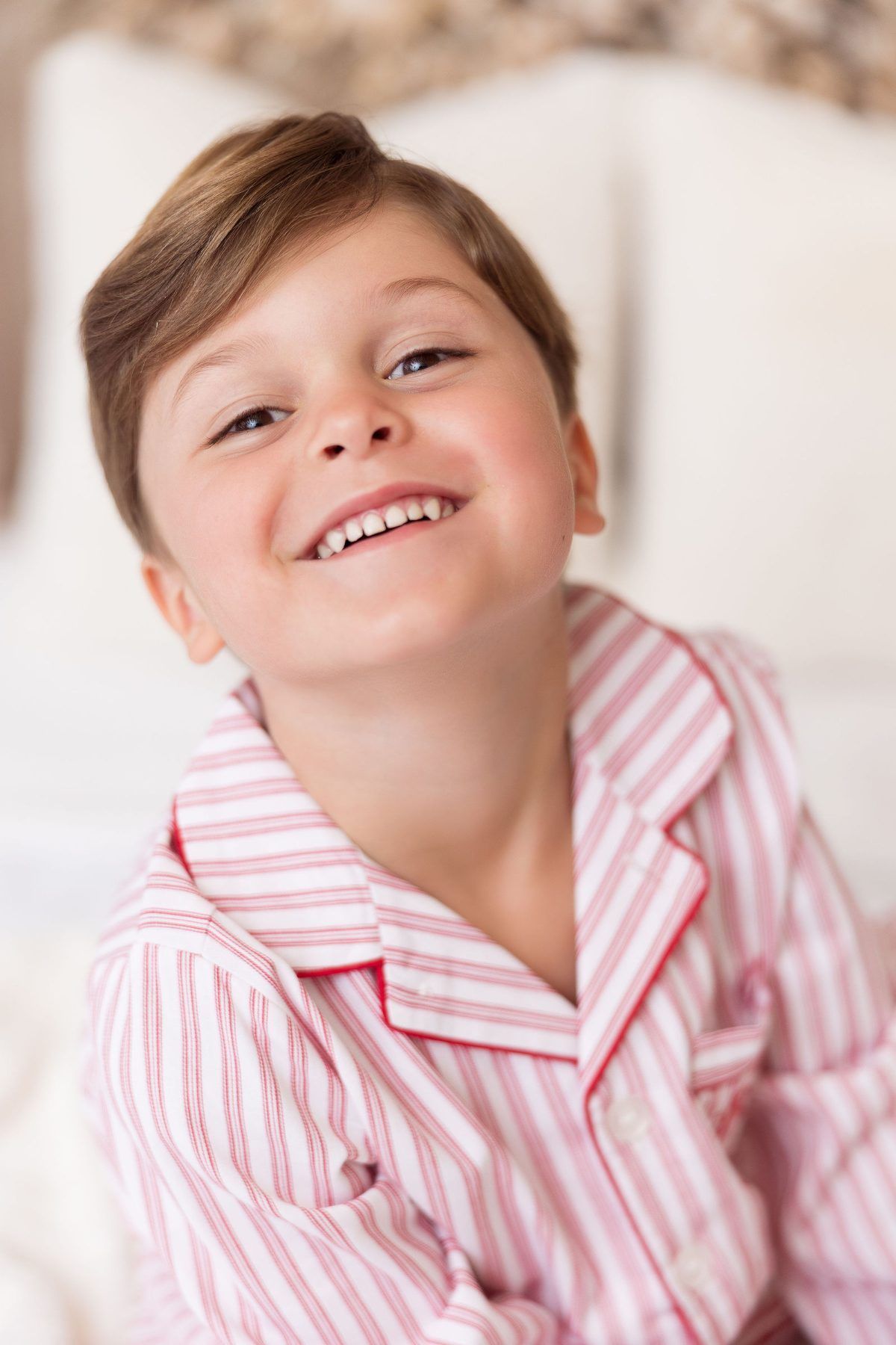 Smiling boy in red striped Christmas pajamas at a Milk and Cookies Christmas mini session near Carmel