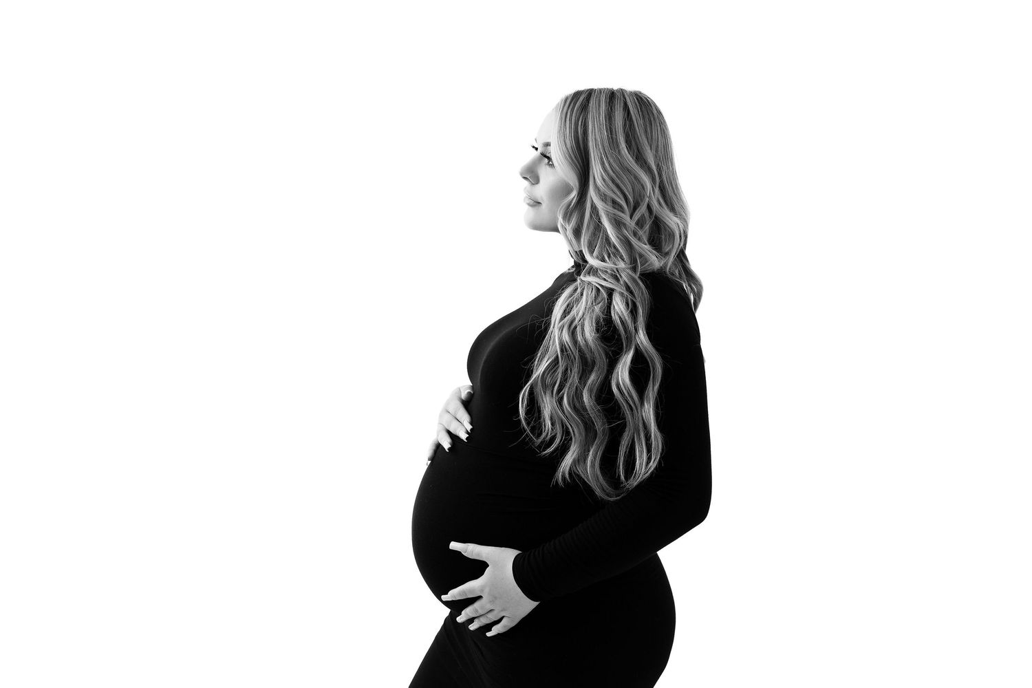 Silhouetted maternity portraits in black showing expectant figure against white backdrop.