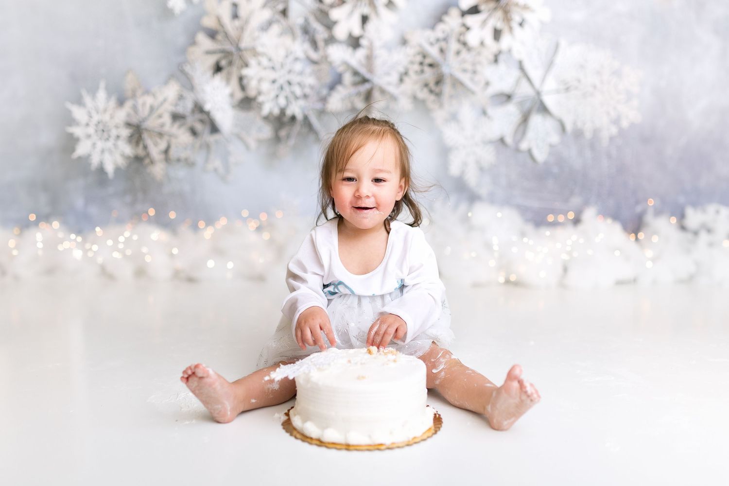 Winter themed baby photo with white snowflakes and decorations.