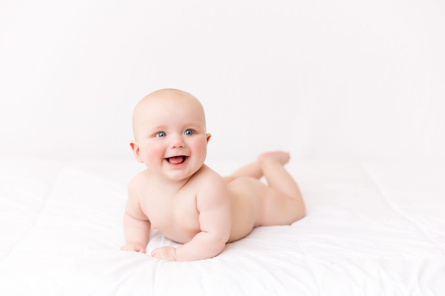 Natural light baby photography on white background showing developmental milestones.