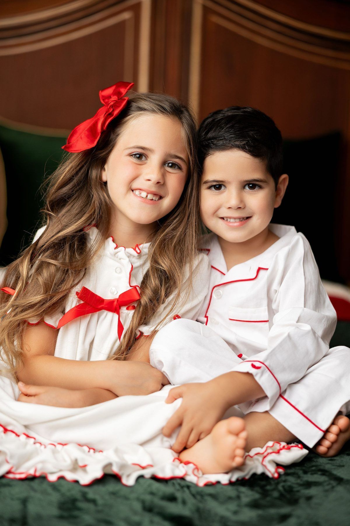 Sister and brother cuddling in white Christmas pajamas, Monterey Christmas sibling photos