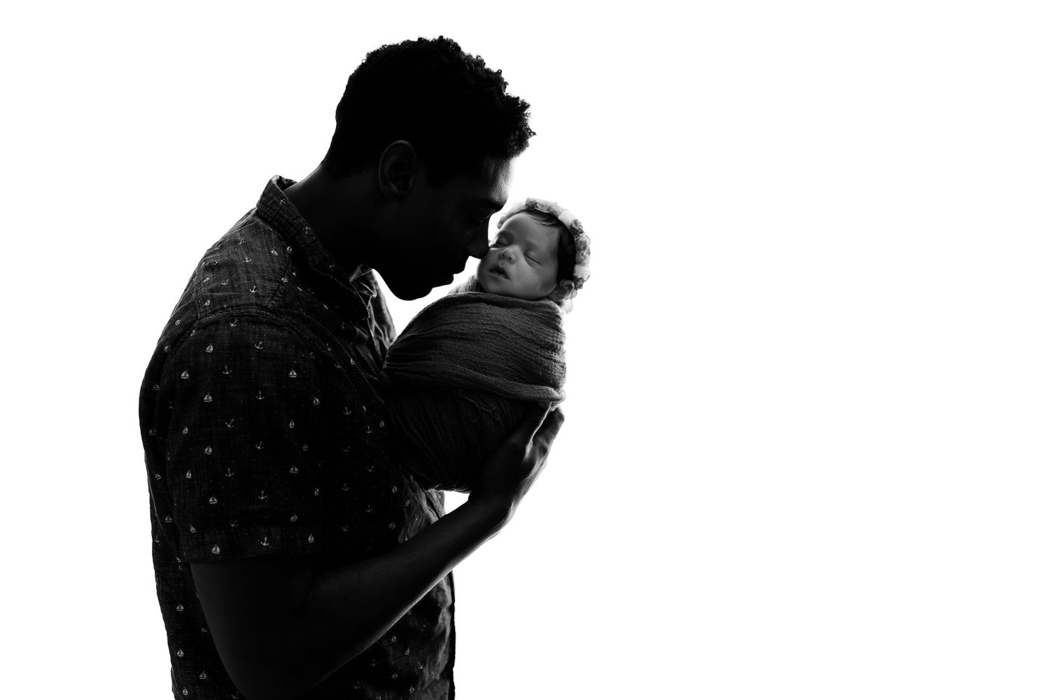 Silhouette of romantic couple embracing against dark background.