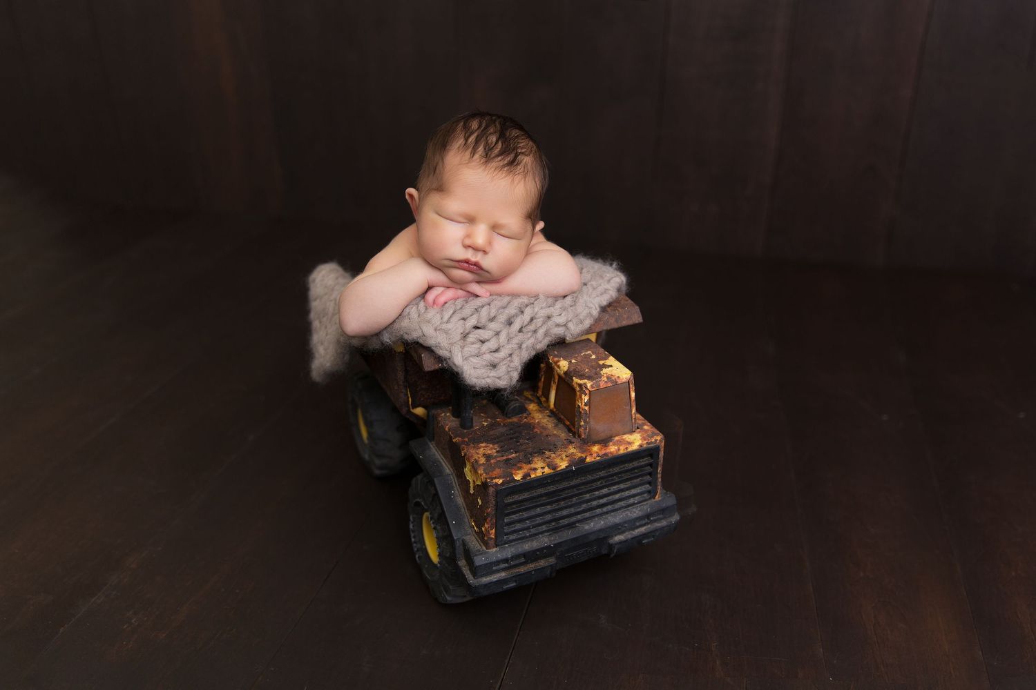 Vintage car toy with worn patina sits against a dark background creating a moody nostalgic scene.